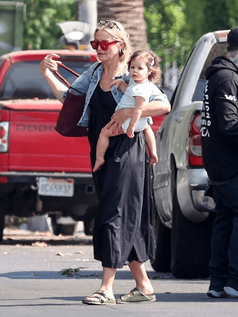Cameron Díaz cargando a su hija cruzando una calle 