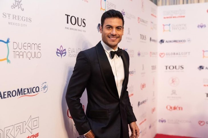 Carlos Rivera posando para una foto en la alfombra roja de la gala global gift
