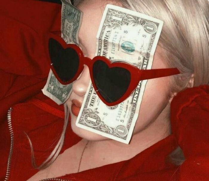 Chica con lentes oscuros y dólares entre los ojos y las gafas