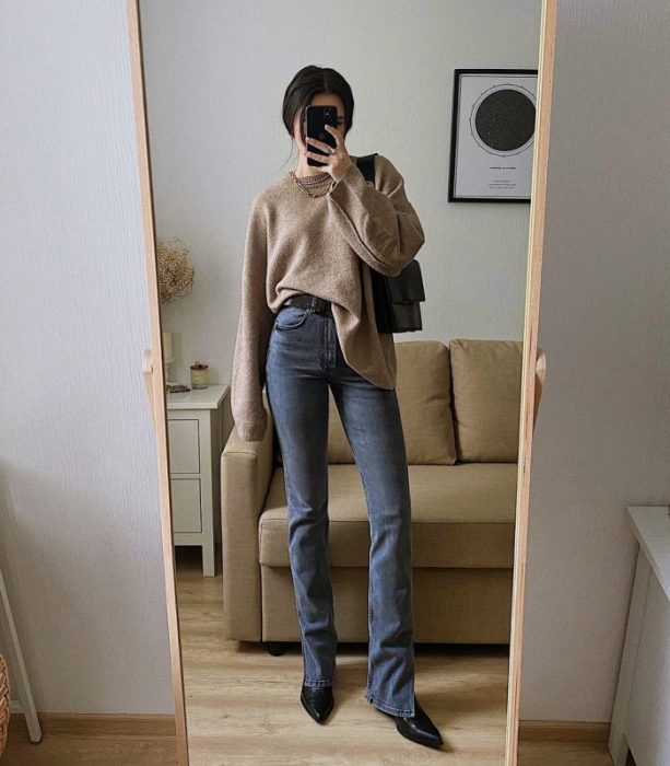 Chica usando jeans y suéter en un look navideño