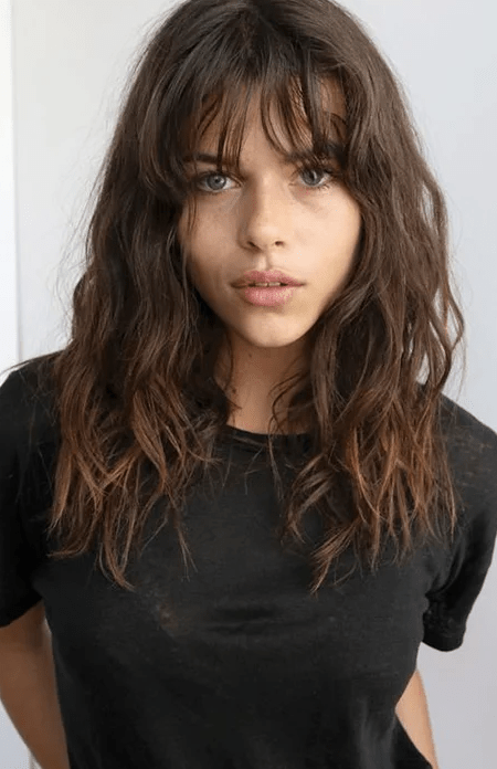 Mujer castaña de cabello suelto y despeinado o capas