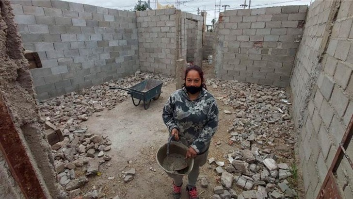 Mujer haciendo su hogar ladrillo por ladrillo