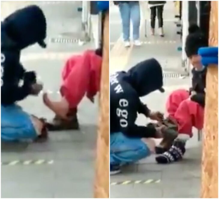 Hombre poniendo calcetines a una abuelita sin hogar