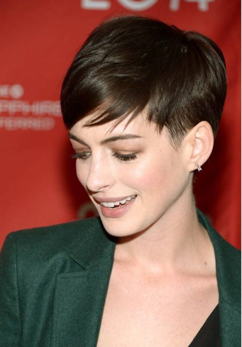 Anne Hathaway con corte pixie usando una americana verde oscuro