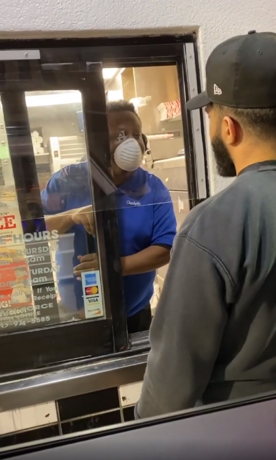 Hombre hablando con un empleado de un restaurante de comida rápida