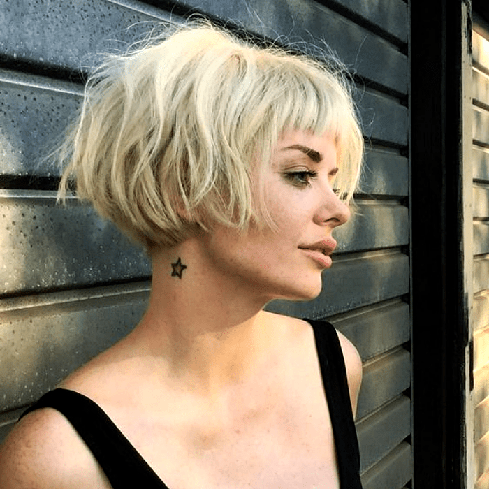 chica rubia con corte estilo bob francés, french bob usando un top negro de tirantes