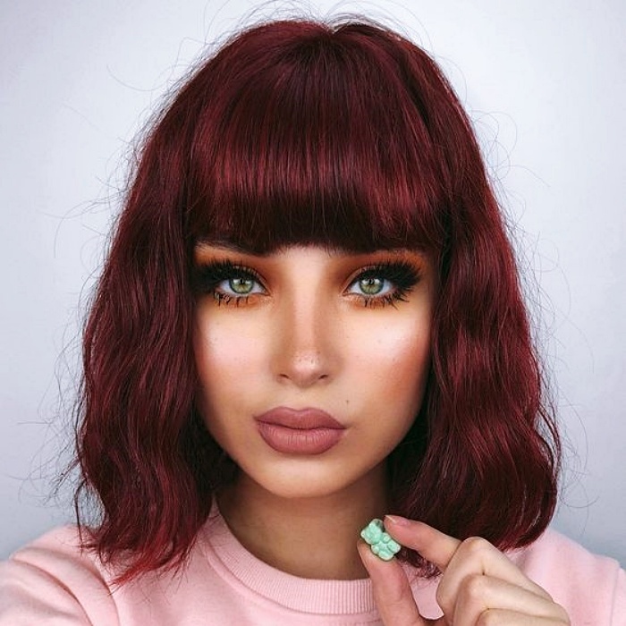 chica con cabello corto con fleco color borgoña, rojo intenso