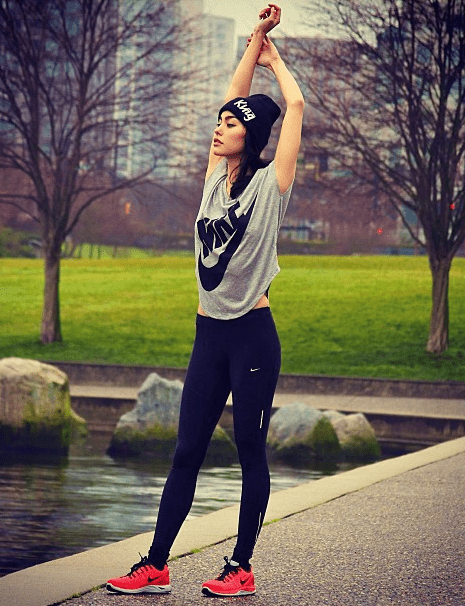 Chica con ropa deportiva ejercitándose en parque