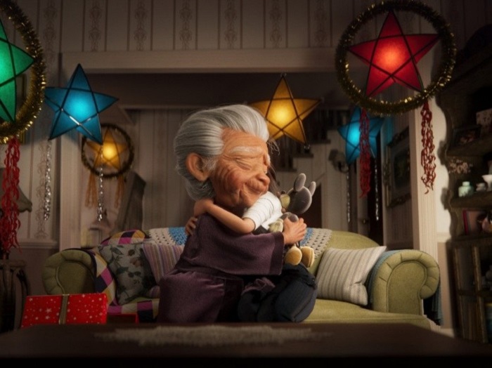 Escena del corto animado de Disney, donde la abuela abraza a su nieta y sostiene un peluche de Mickey Mouse
