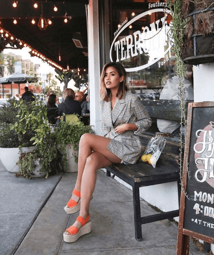 Chica con traje corto y sandalias de plataforma