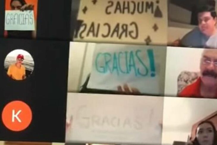 Alumnos muestran papeles con la palabra gracias a su profesor