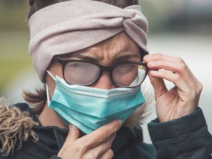 Mujer usando cubrebocas con los lentes empañados
