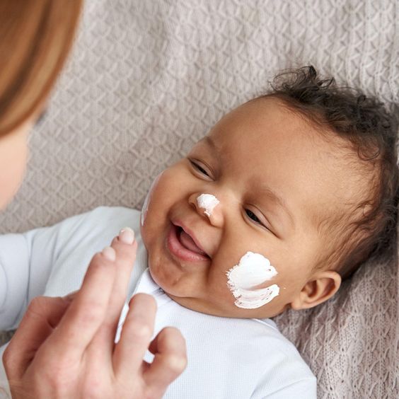 Bebé con crema en la cara
