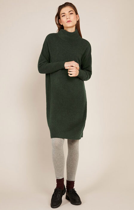 Chica usando un maxisueter de color verde con botines
