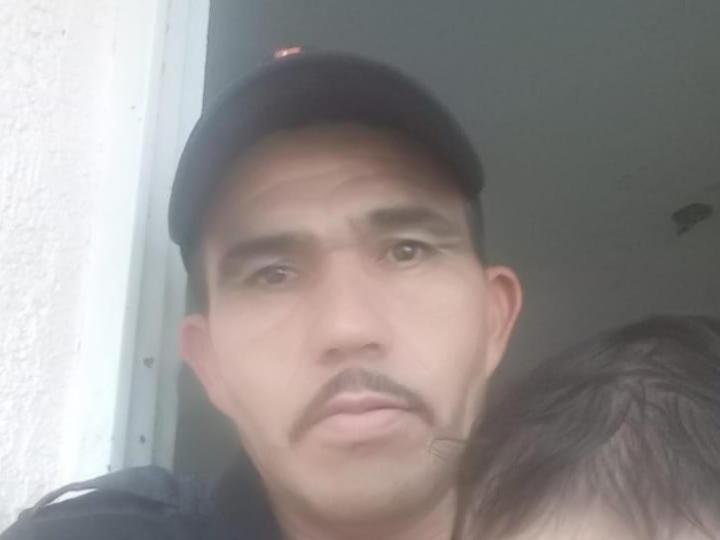 Hombre sentado en la banqueta de la calle 