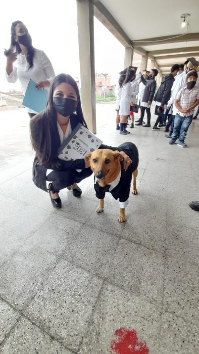 mujer en cunclillas posando a lado de un perro que recibió un reconocimiento en una escuela en Argentina