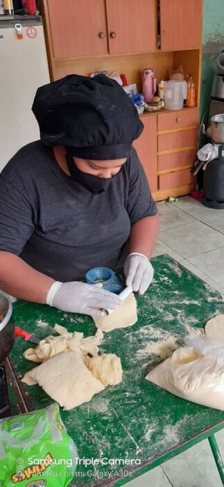 Chica cocinando empanadas; Vende empanadas caseras para cumplir su sueño de ser militar e internet ya salió al rescate
