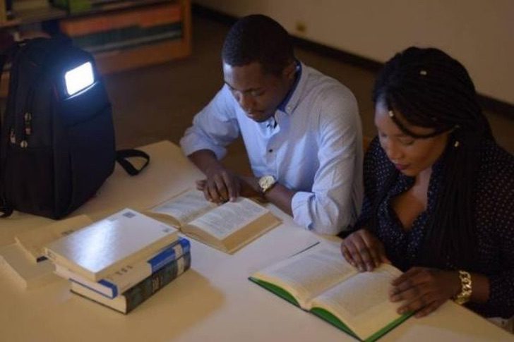 Mike Bellot estudiando junto a una amiga mientras usan su mochila con paneles solares