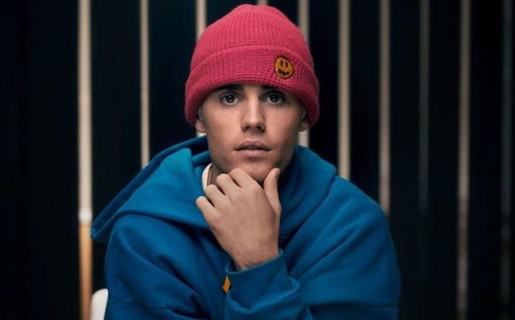 Justin Bieber sentado en una silla modelando su línea de ropa deportiva