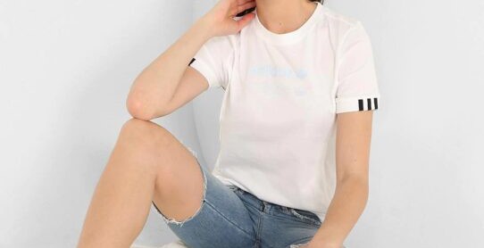 Chica sentada vistiendo shorts, camisa de color blanca