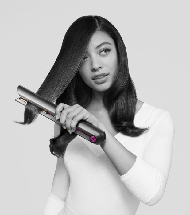 Chica planchando su cabello con la plancha Dyson Corrale