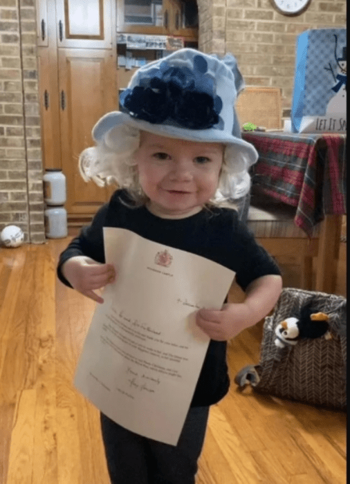 niña con la carta que le envió la Reina Isabel II luego de disfrazarse de ella en Halloween 