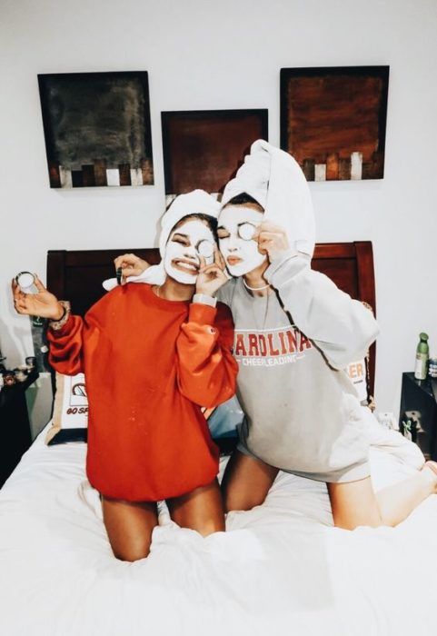 Amigas en una pijamada con mascarillas y tomándose fotos