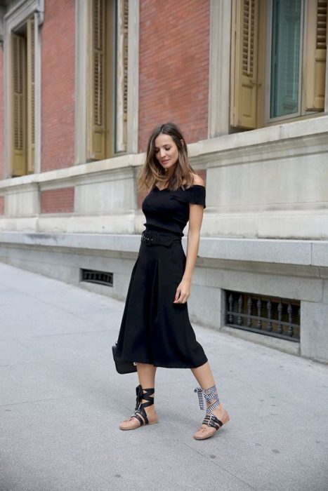 Mujer de cabello largo con vestido negro y ballerinas