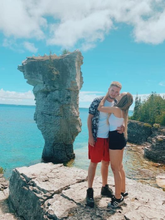 Danisha y Riley abrazados y besándose cerca del mar