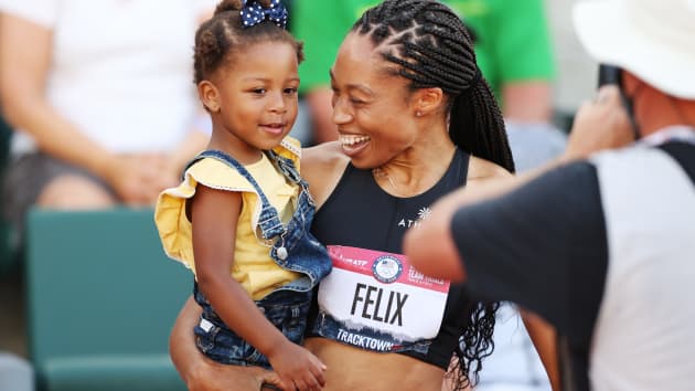 Mujer cargando a su hija; Allyson Félix, la atleta que discriminó por ser madre y regresó a casa con una medalla olímpica