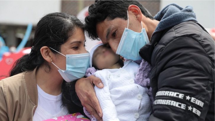 Diana y su esposo abrazando a su bebé después de ser dadas de alta del hospital