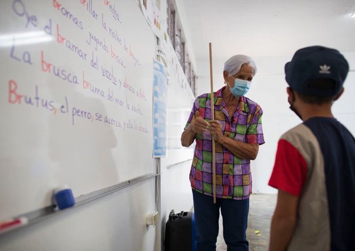 Lilia María Rivera Morales, profesora, enseñando a alumno; Profesora de 89 años sigue educando a los niños de Puerto Rico (1)