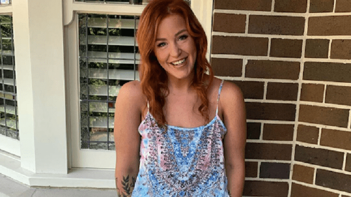 Alida posando para una foto después de haber adelgazado, vistiendo una blusa azul