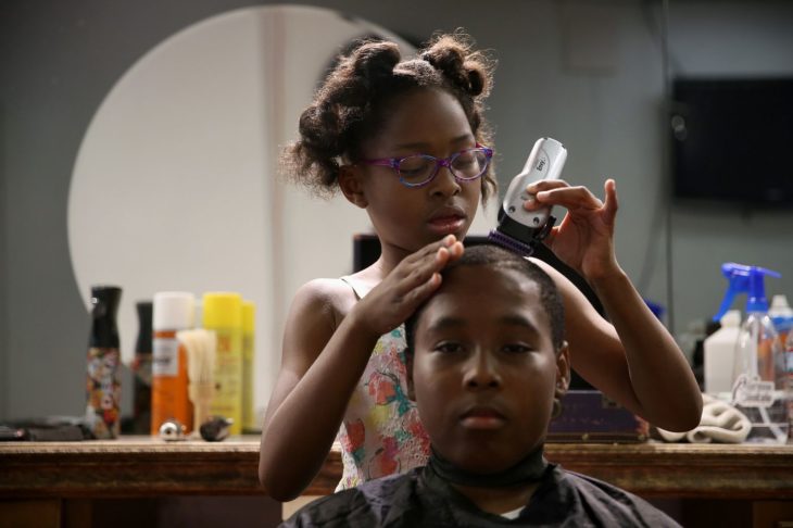 Neijae Graham-Henries cortándole el cabello a un niño