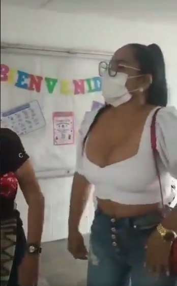 Mujer usando jeans y blusa blanca mientras está en una escuela 