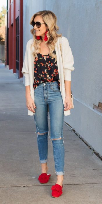 Chica usando skinny jeans con zapatos rojos, blusa negra y cárdigan blanco