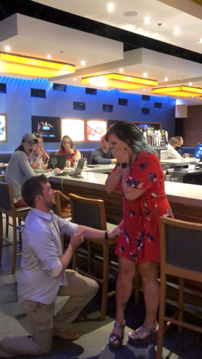 Pareja fingiendo propuesta de matrimonio en un restaurante, Corinne Miller y Adam Carroll