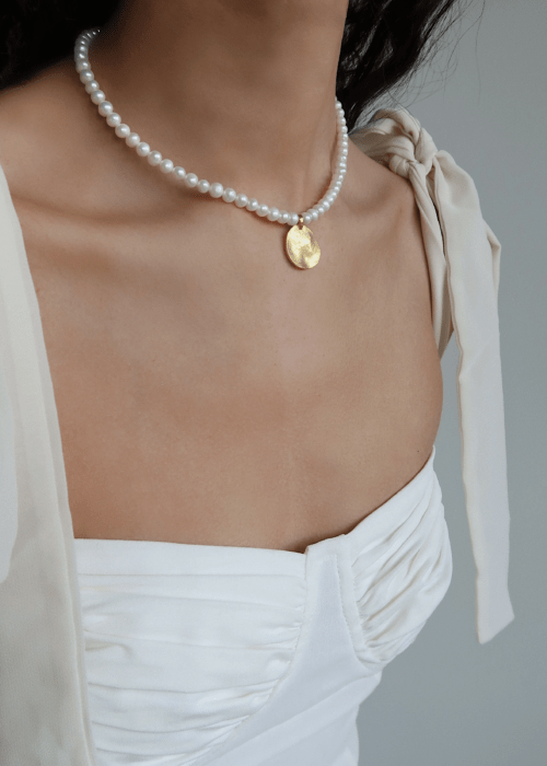 collar de perlas con medallón de oro
