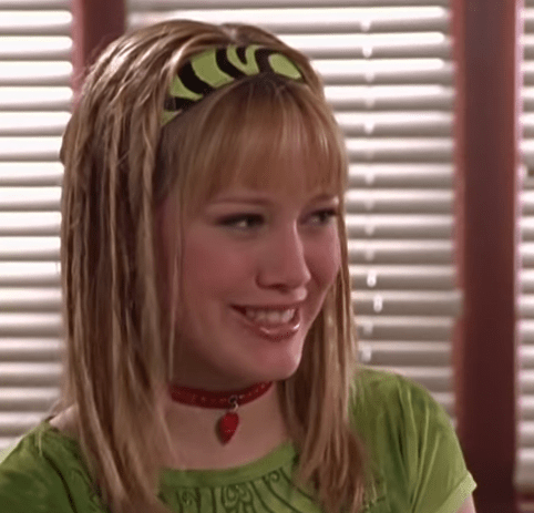 Personaje de Lizzie McGuire usando una diadema de cebra en color verde 