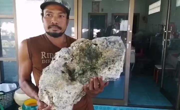 Pescador sosteniendo ámbar gris de una ballena
