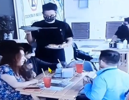 Familia poniendo cabellos en la comida de un restaurante
