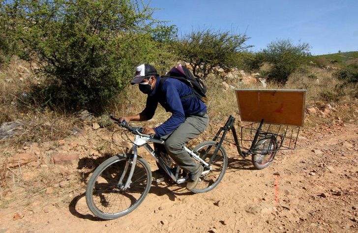 Maestro conduciendo su bicicleta para dar clases en una comunidad indígena