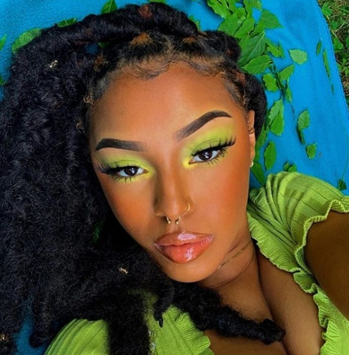 chica de complexión morena con maquillaje monocromático de color verde, playera de color lima