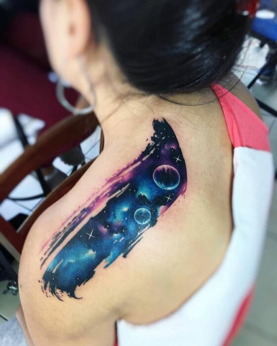Chica con un tatuaje de planetas en varios colores