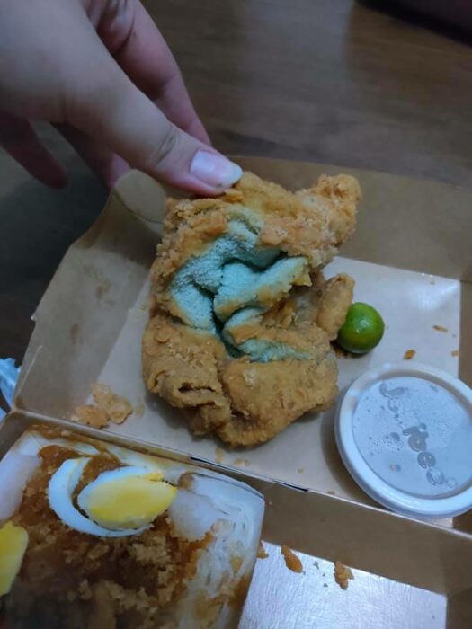 Chica abriendo un pollo frito que en realidad era una toalla