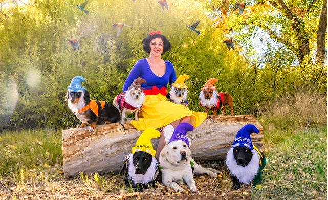 Mujer disfrazada de Blancanieves junto a sus siete perros