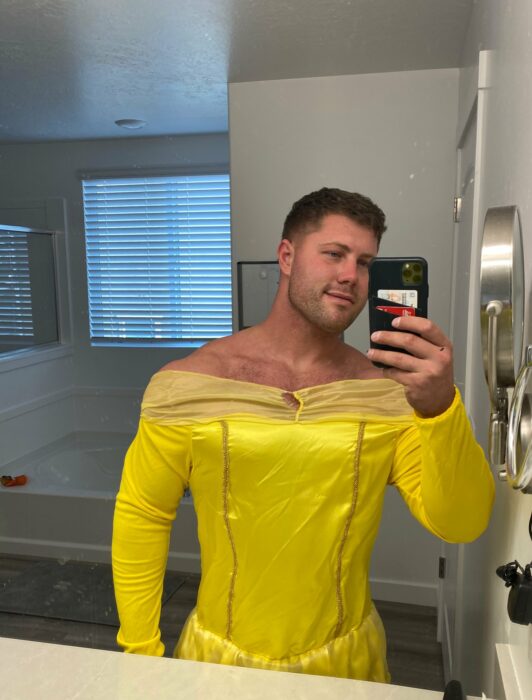 Hombre tomándose una selfie mientras está vestido de Bella de la película La Bella y La Bestia