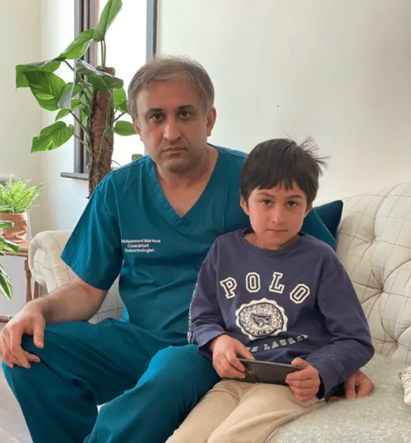 Niño sentado junto a su padre mientras se toman una fotografía 