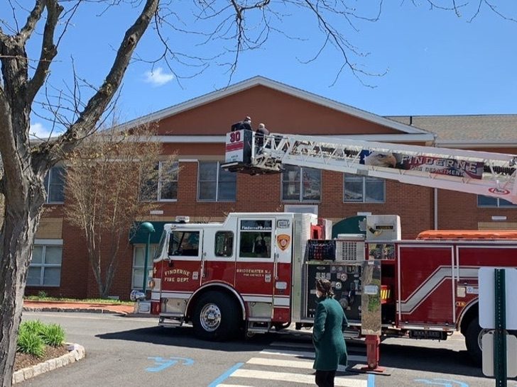 Camión de bomberos subiendo a un hombre en grúa