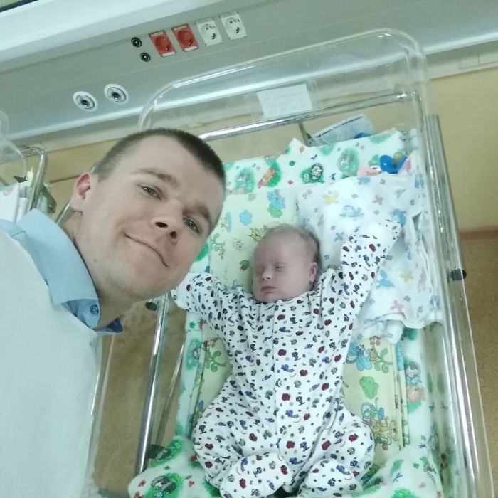 Papá tomándose una selfie junto a su hijo mientras el bebé está en los cuneros 
